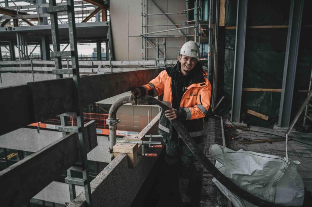 Betonpompmachinist bevestigt standleidingen voor veilige en efficiënte betonstort