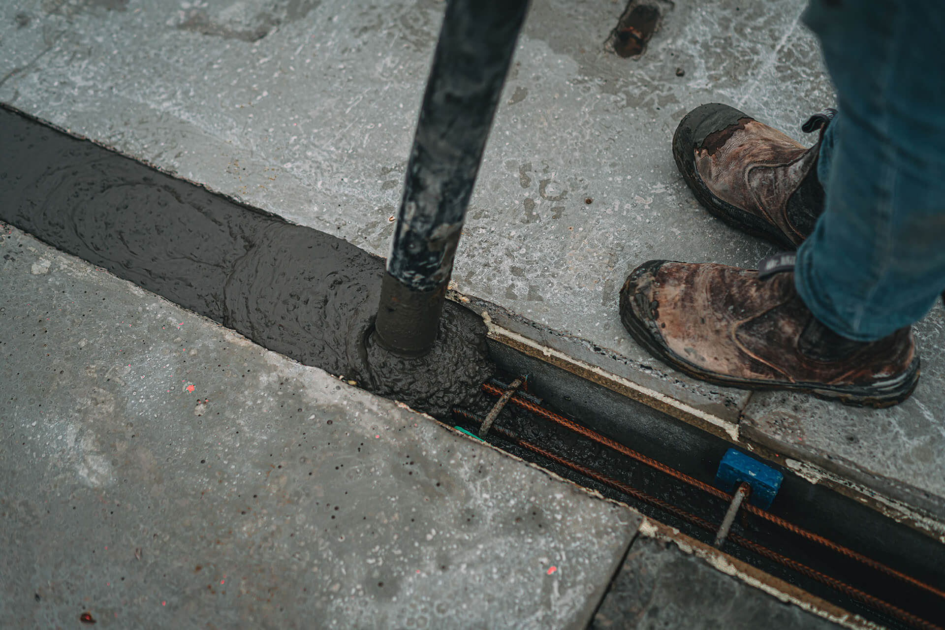 Je ziet hoe een naad gevuld wordt met beton van een kanaalplaatvloer