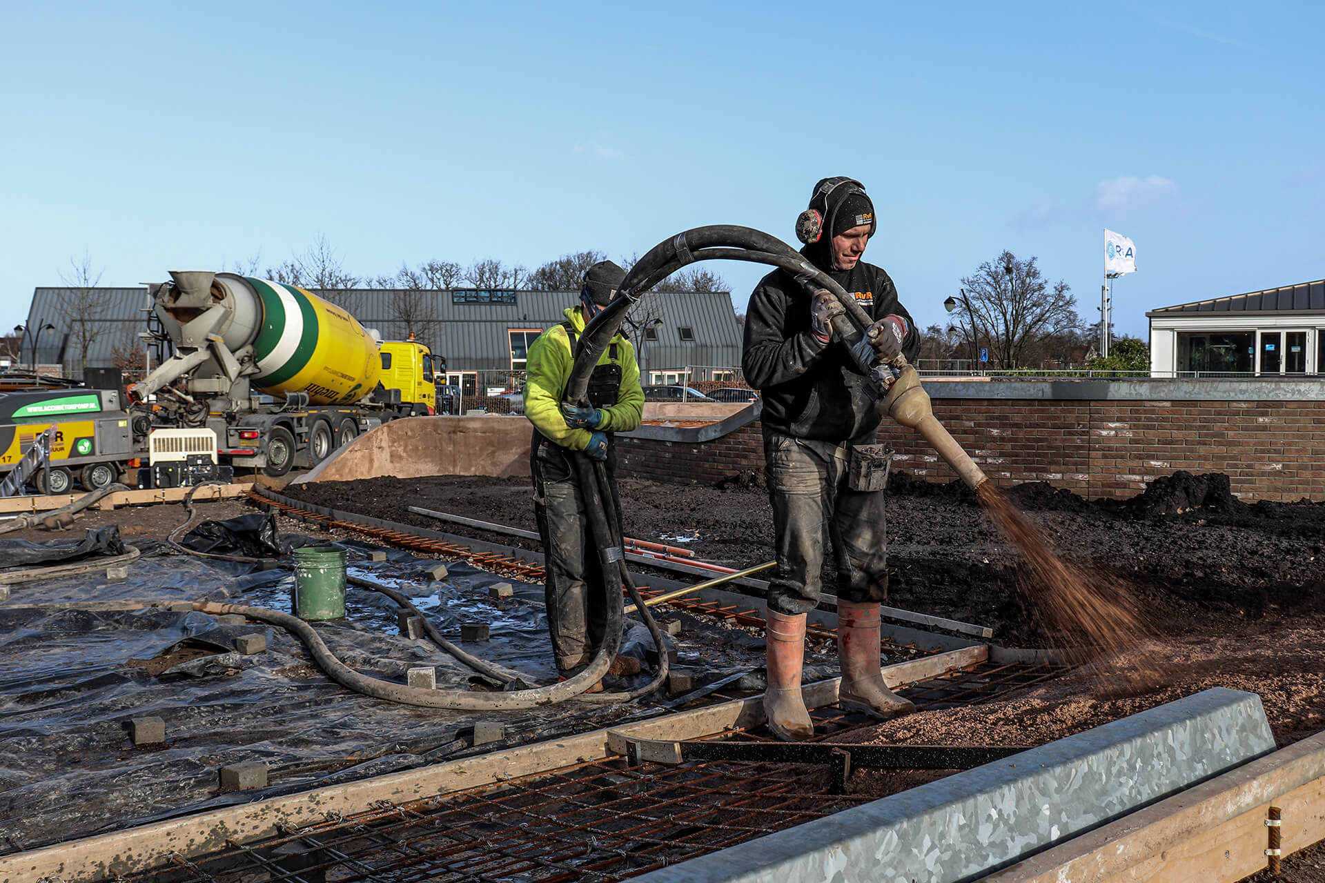 Spuitbeton applicatie op een muur door RvR Betonpomp Verhuur voor versterking en afwerking van betonstructuren. Zakelijk Spuitbeton wordt toegepast op een muur op een bouwplaats door een specialist van RvR Betonpomp Verhuur.