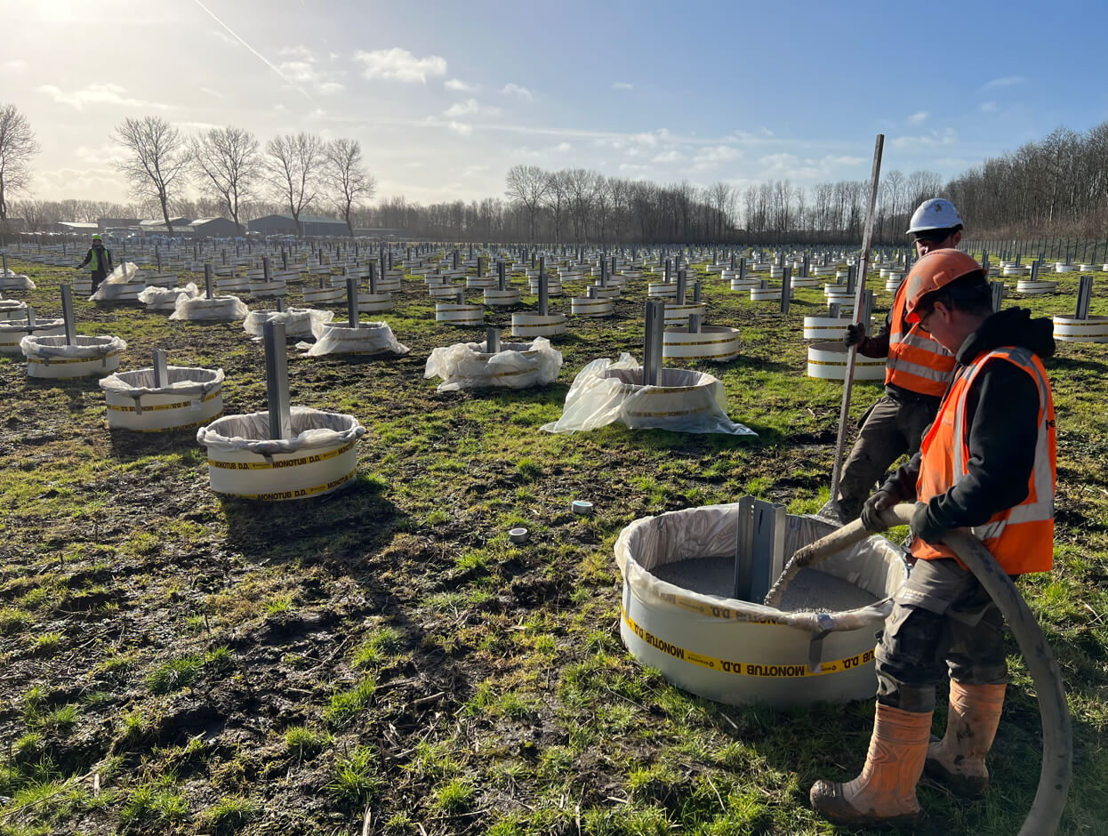 Beton wordt gestort voor de poeren van zonnepanelen, essentieel voor de fundering van zonnepaneelinstallaties