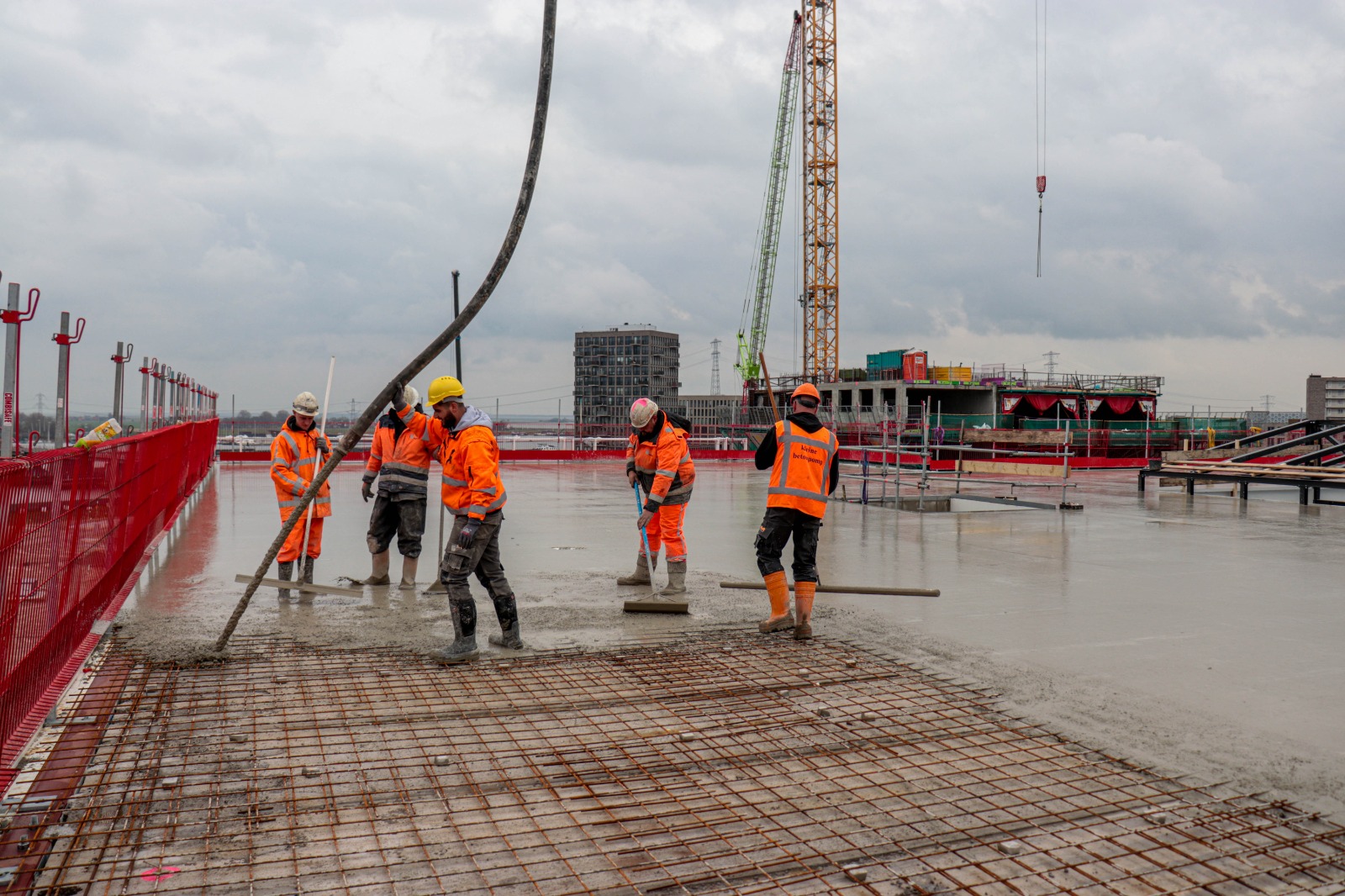Betonvloer storten op het dak met een stortploeg Betonvloer storten met een stortploeg op het dak van de bouwplaats