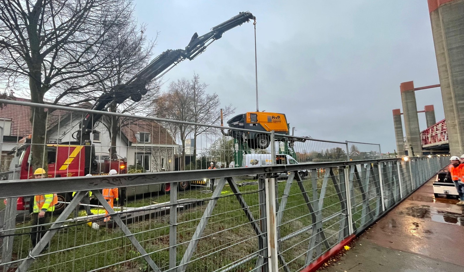 Kleine betonpomp wordt opgehesen met een hijskraan