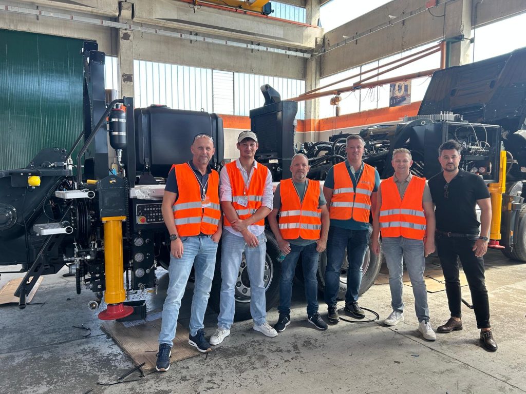 Groepsfoto bij CIFA bij de giekpomp met RvR Betonpomp Verhuur