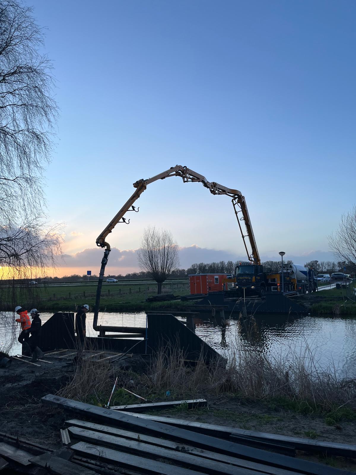 Palen storten voor een brug in Avenhorn 😄 Met de giekpomp stonden we aan één kant van het water, terwijl we palen in het water hebben gevuld met beton voor de nieuwe brug. Precies dit soort klussen maken een giekpomp ideaal. Je positioneert de giek exact waar je moet zijn, ook als je er zelf niet direct bij kunt. Dat vraagt natuurlijk wel om een machinist met ervaring en gevoel voor het werk. Gelukkig zat dat bij onze machinist Niels helemaal goed.
